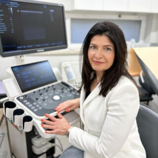 Hand of doctor touching aged patient to support and reassure her